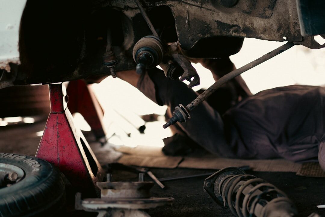Mechanic restoring a vintage automobile chassis in a workshop