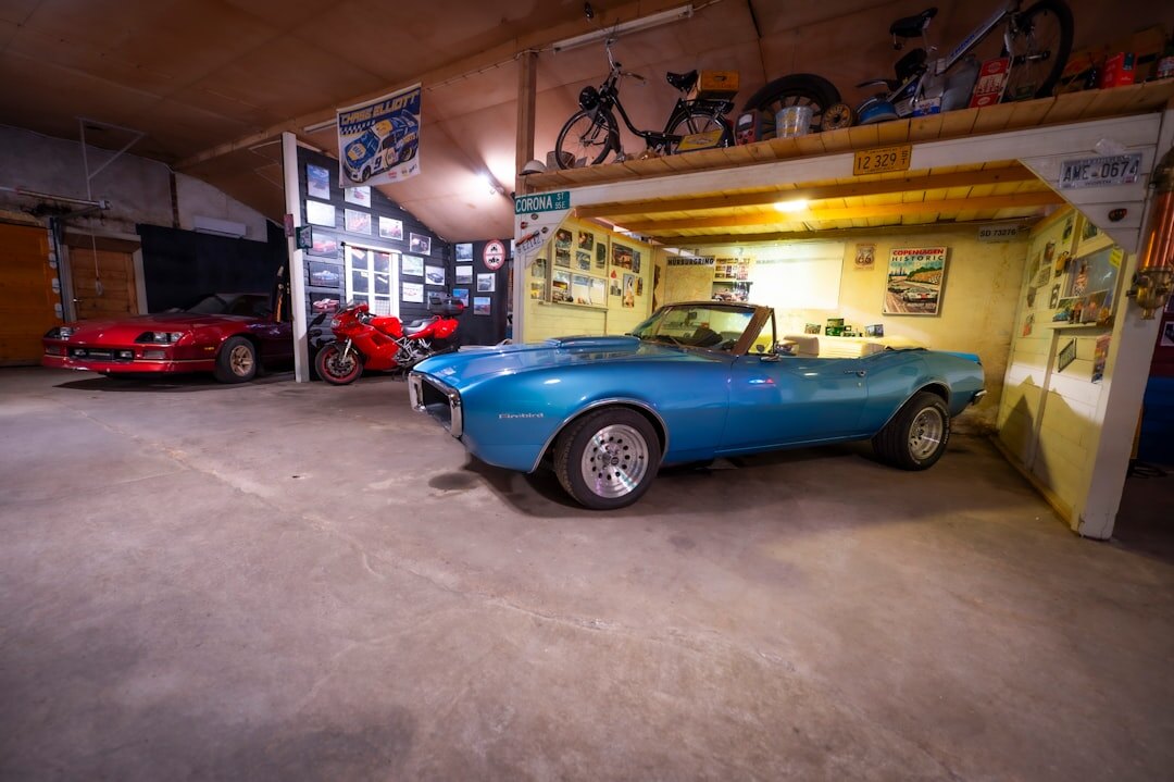 Private collector garage filled with rare vintage automobiles under warm lighting