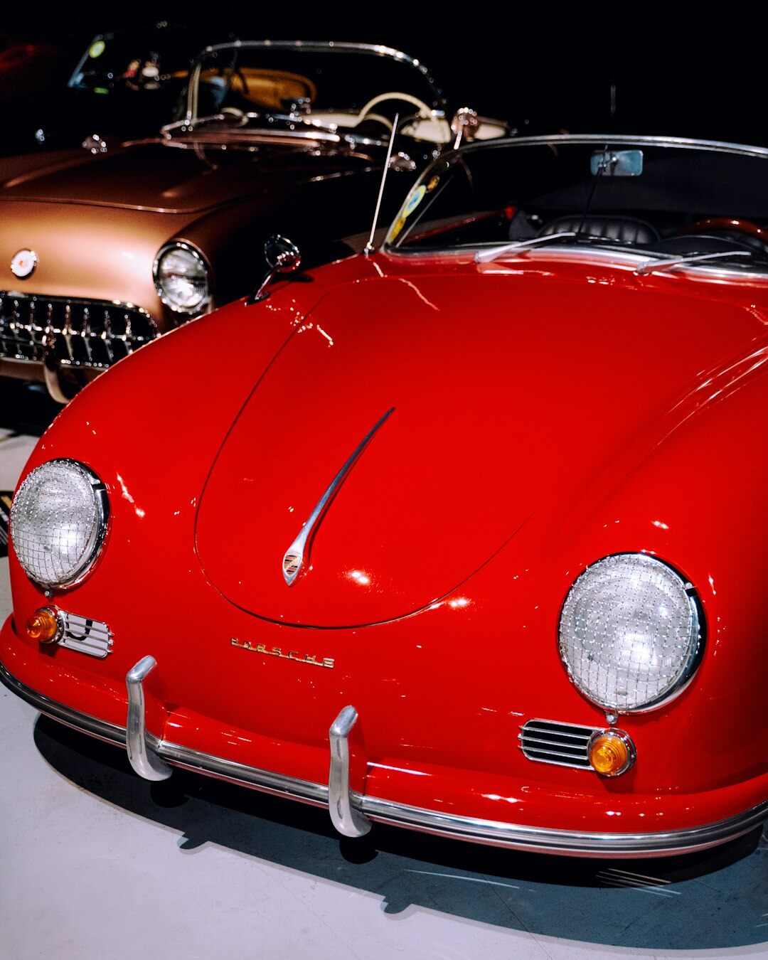 Front three-quarter view of a restored classic automobile in a museum gallery