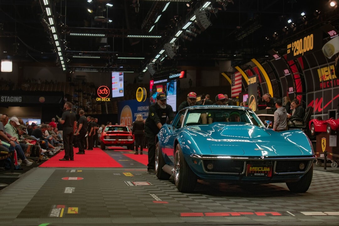 Classic red Italian sports car displayed at an auction house under spotlight